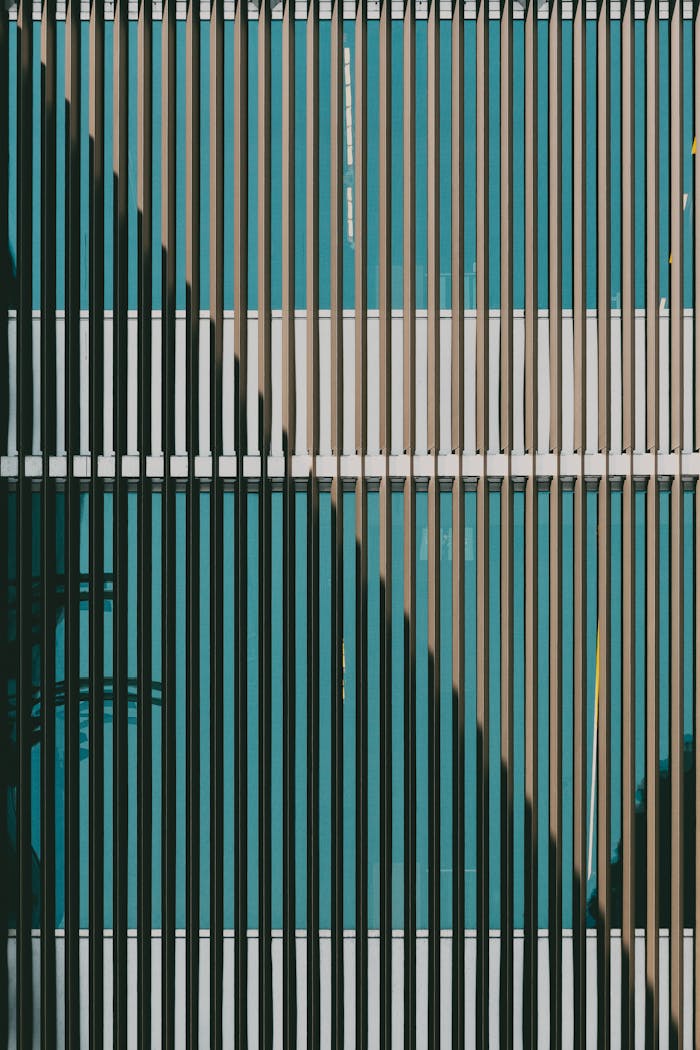 Abstract view of a modern building's vertical striped window pattern with geometric shadows.